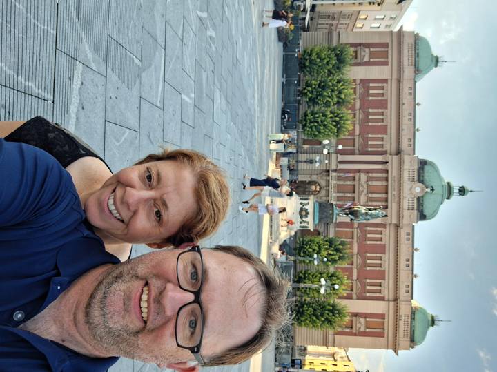 Couple selfie in Belgrade’s Republic Square with the National Museum and Prince Mihailo statue behind them.