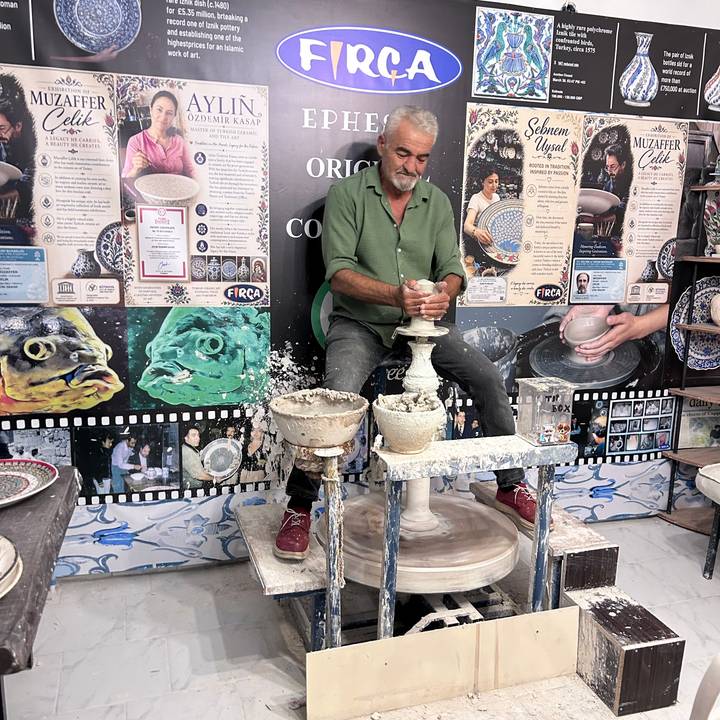 Potter demonstrates wheel-throwing technique, shaping clay in a traditional Cappadocia workshop.