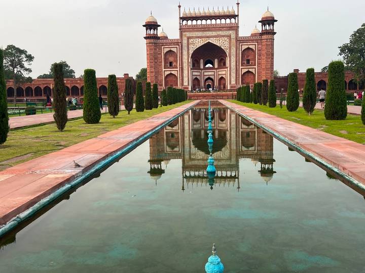Grand Mughal gateway and reflecting pool perfectly mirror the intricate red sandstone architecture.