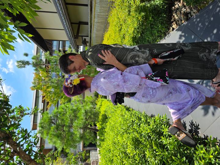 Romantic couple in traditional yukata share a playful pose in a tranquil Japanese garden.