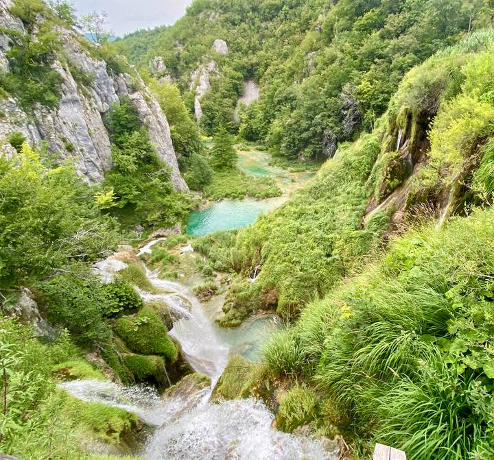 Verdant limestone canyon with cascading turquoise pools and waterfalls in Plitvice Lakes National Park.