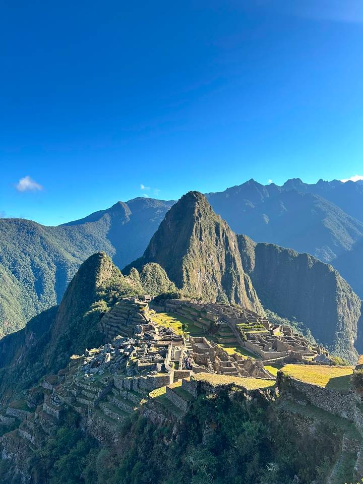 Iconic Machu Picchu terraces and Huayna Picchu peak rise majestically above lush cloud forest.