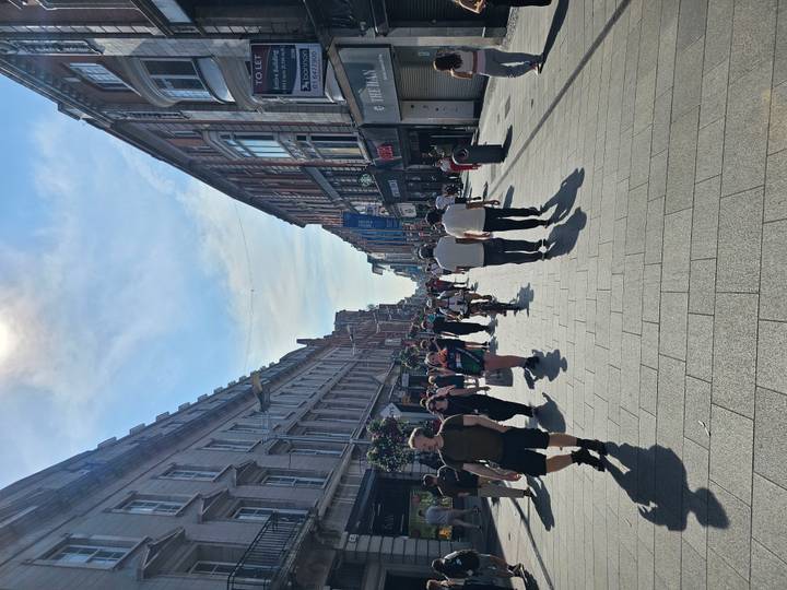 Busy pedestrian shopping street in Dublin filled with people under bright sun