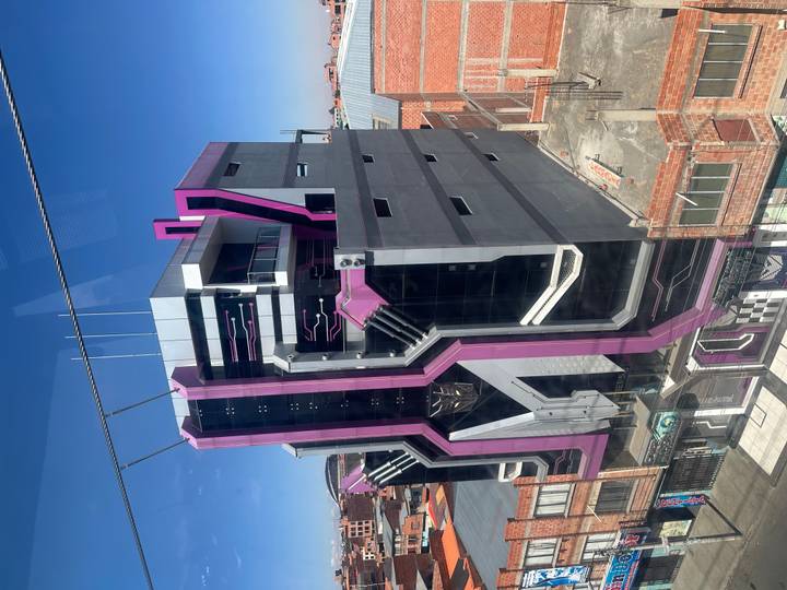 Futuristic purple-and-black high-rise with bold geometric design stands against a clear sky in La Paz.