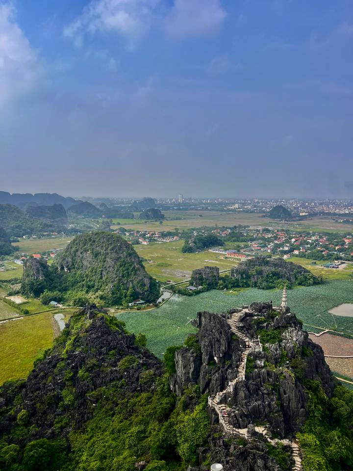Panoramic aerial view over karst peaks, rice paddies and townscape from a high viewpoint