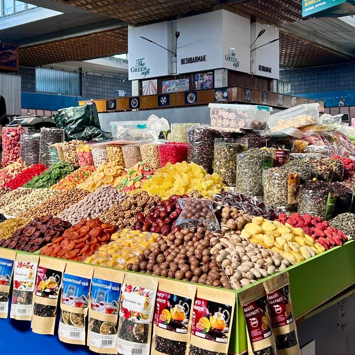 Vibrant market stall piled high with assorted dried fruits, nuts and sweets.