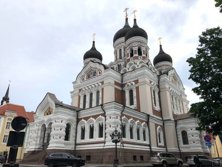 Ornate Orthodox cathedral with black onion domes, white trim and red-brick accents.