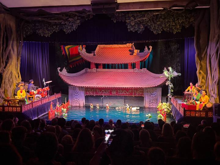 Traditional Vietnamese water puppet performance on a small stage pool before a seated audience