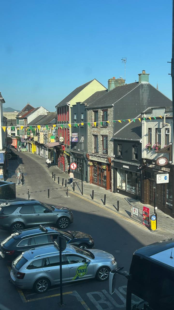 Colorful narrow street in Galway lined with traditional pubs and bunting overhead.