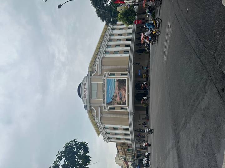Trang Tien Plaza, an elegant cream-colored colonial style department store, anchors a busy Hanoi intersection.