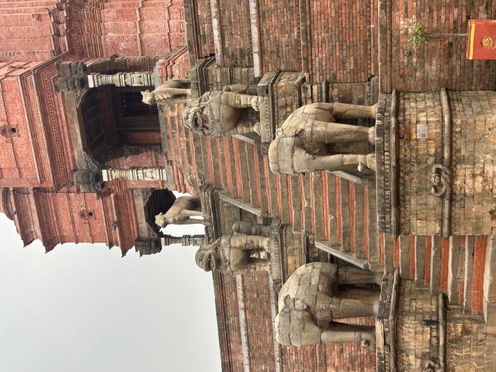 Stone stairway flanked by carved lion and elephant guardians in ancient square