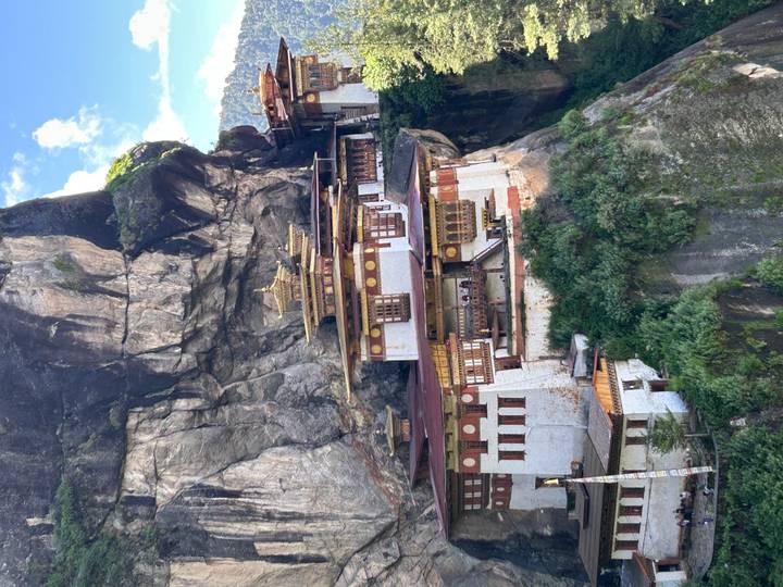Dramatic cliff-side Tiger's Nest Monastery perched on rocky face amid lush forest