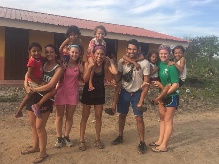 Group of people with children posing in front of a building.