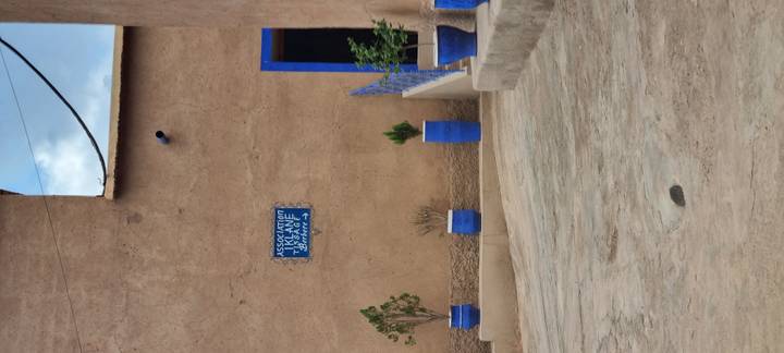 Adobe wall accented with vivid blue flower pots and blue trimmed doorway.