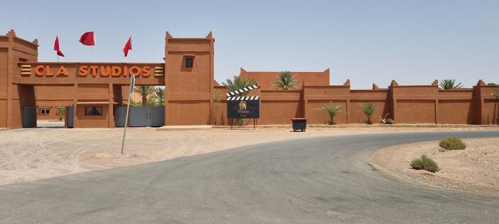 Entrance of CLA film studios with desert backdrop and Moroccan flags.