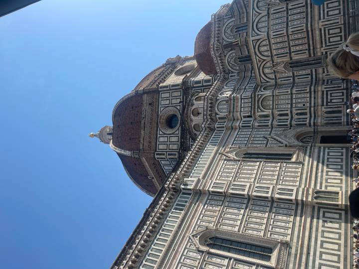 Impressive marble dome and ornate facade of Florence’s Duomo under bright blue sky.