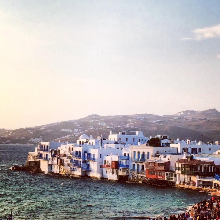 Picturesque view of white buildings on a slope with the sea in the background.