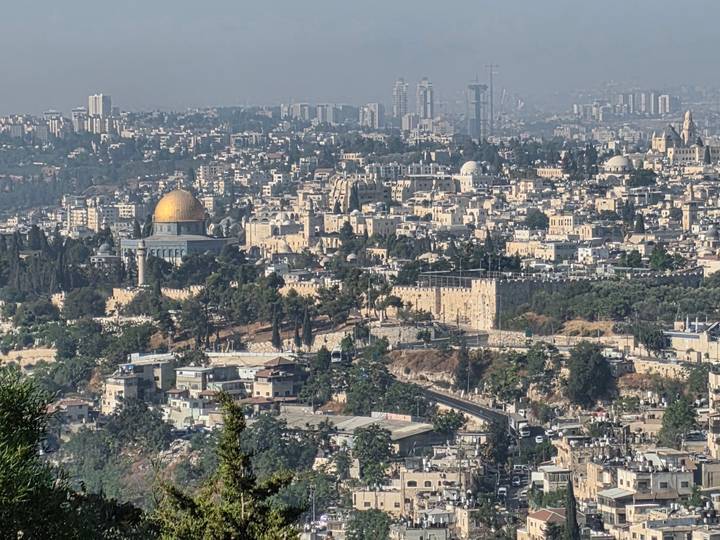 Panoramic cityscape of Jerusalem featuring the gold-domed Temple Mount amid dense historic buildings.