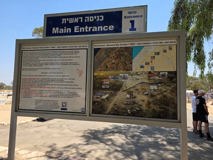 Informational panel and map at the main entrance of a memorial site with Hebrew and English text.
