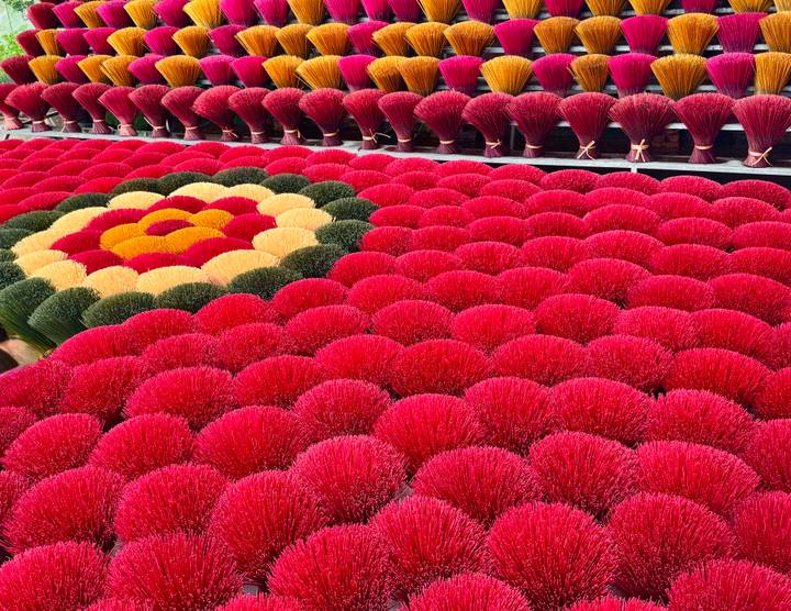 Incense bundles arranged in geometric flower pattern with dominant red color.