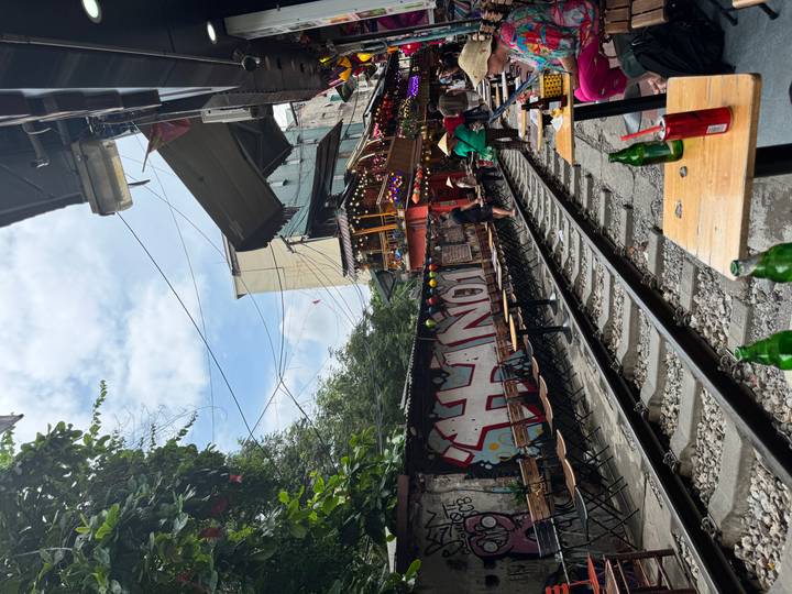 Cafés line the famous Hanoi Train Street where narrow railway tracks run past outdoor seating.
