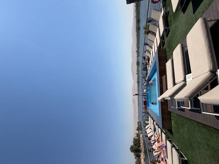 Rooftop pool deck on a Nile cruise ship with loungers and guests sunbathing against a desert backdrop.