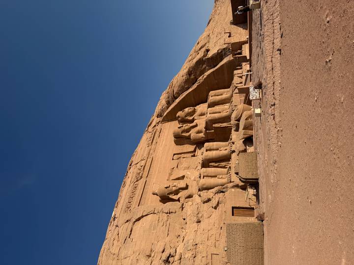 Iconic façade of Abu Simbel with seated statues of Ramses II carved into the cliff.