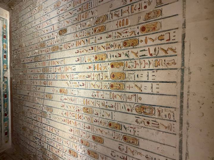 Colourful and detailed hieroglyphic ceiling inscriptions arranged in neat columns.