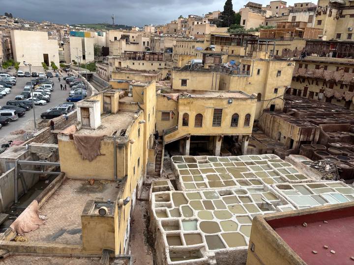 Overhead view of Fes tanneries with honeycomb vats and surrounding yellow buildings.