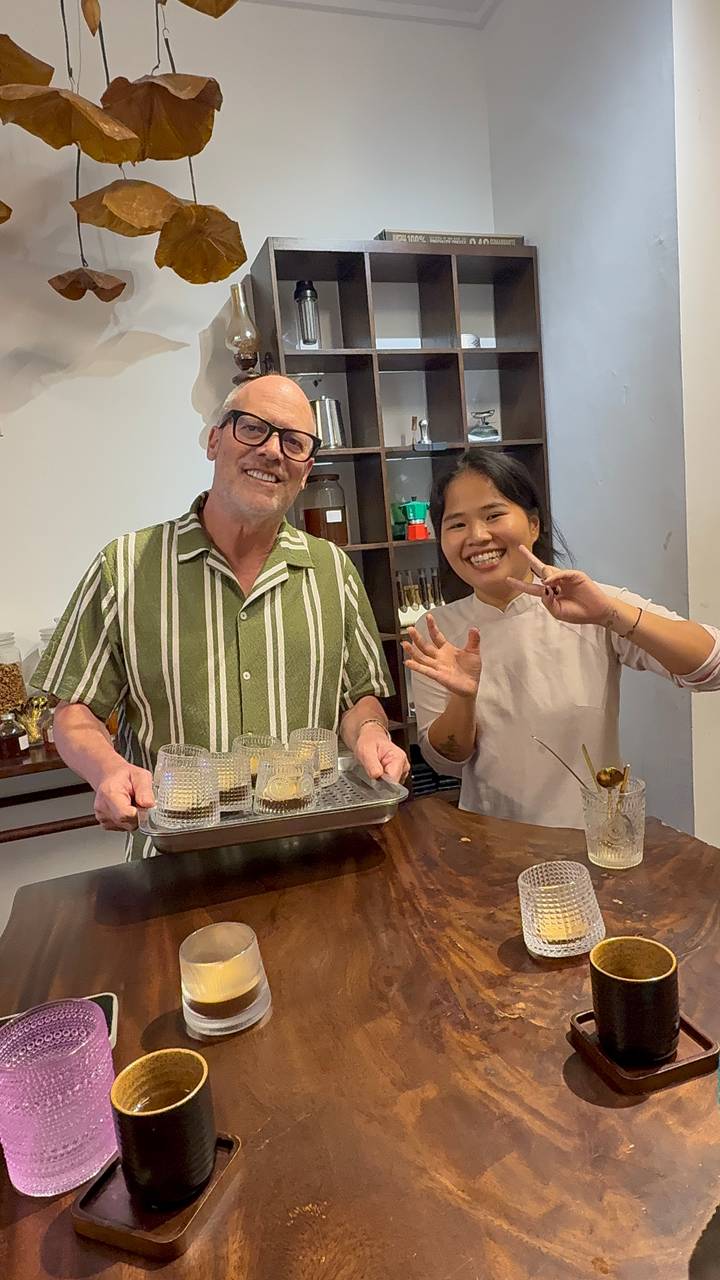 Local instructor and tourist share coffee samples during a tasting workshop.