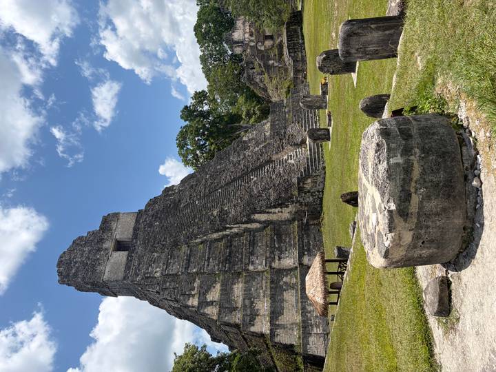 Steep pyramid temple of Tikal rising against a bright blue sky.