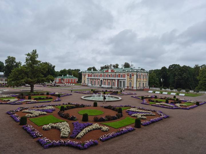 Formal baroque gardens and fountain facing the pastel façade of Kadriorg Palace in Tallinn.