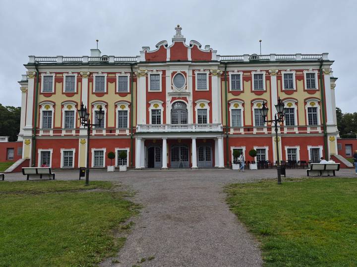Close-up of Kadriorg Palace’s ornate red and yellow façade with visitors near the entrance.