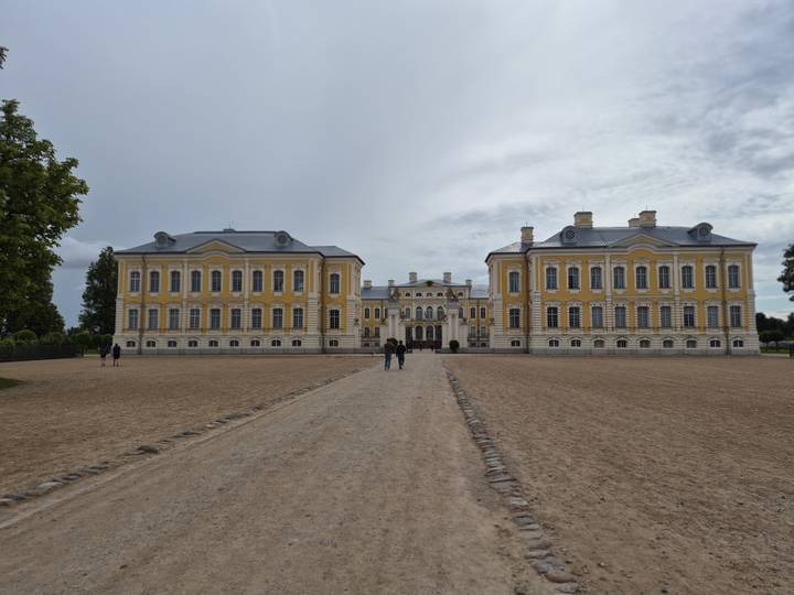 Wide courtyard leading to the grand yellow Rundale Palace, visitors walking toward the entrance.