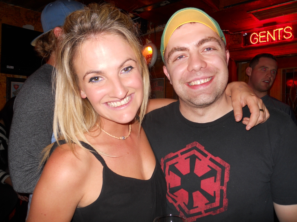 Deux personnes souriant et posant à l'intérieur.