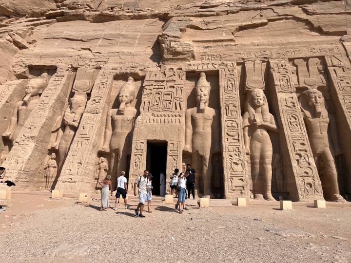 Visitors stand before the colossal statues and hieroglyphs of Abu Simbel's Great Temple.