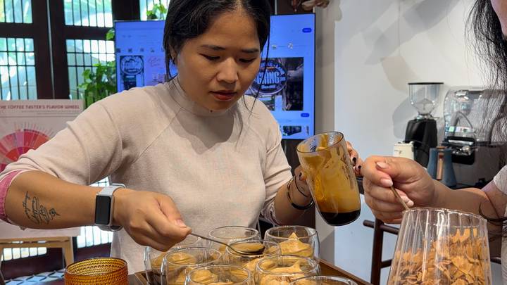 A woman prepares glasses of rich Vietnamese coffee during a tasting workshop.