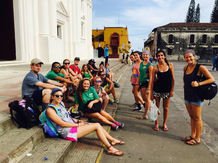 A group of people sitting on the steps of a historic building.