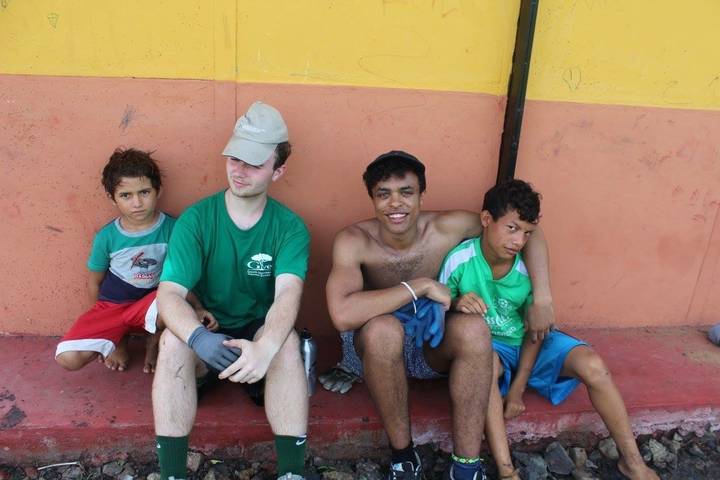 Group of people sitting against a colorful wall.