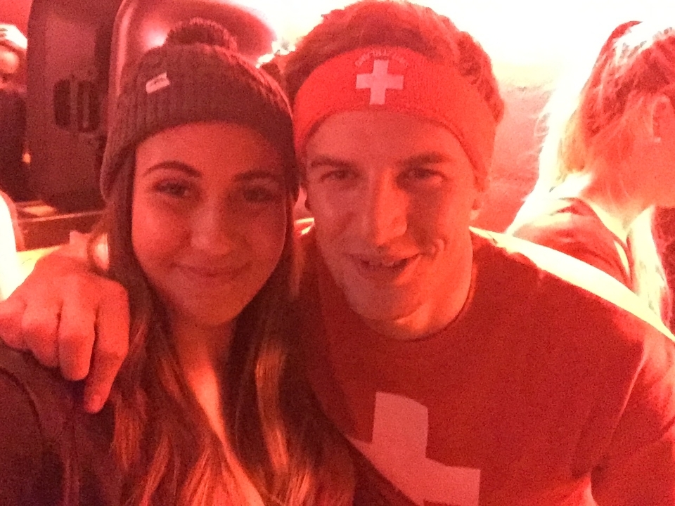Selfie with two people smiling in night lighting.