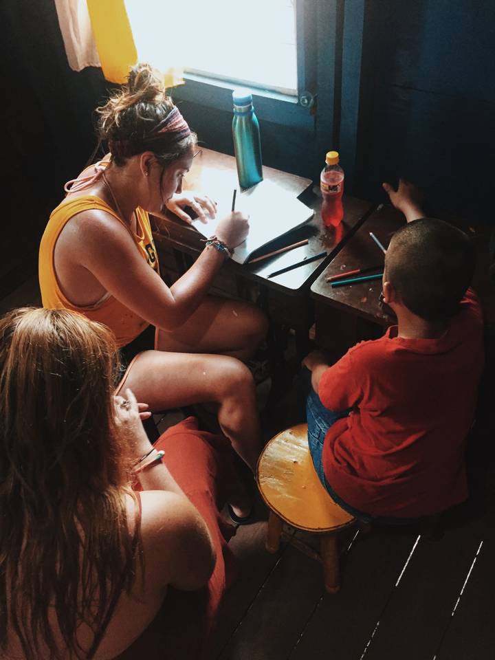 People gathered around a table drawing and coloring.