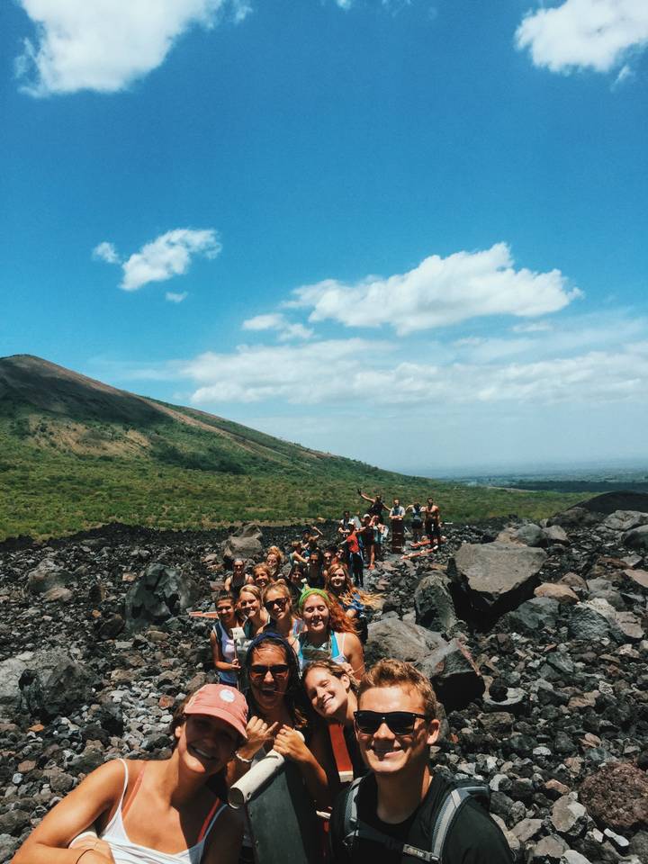Group of people on a rocky landscape with a mountain in the distance.