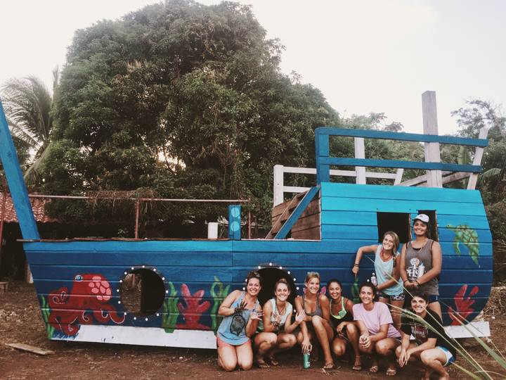A group posing in front of a painted wooden play structure.