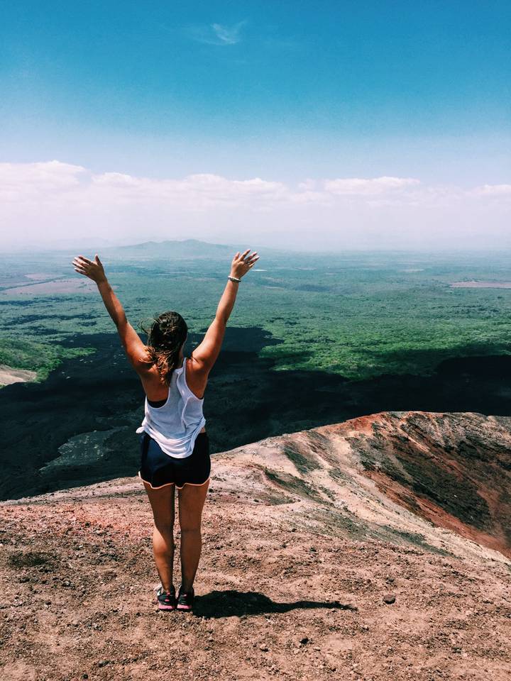 Person with arms raised enjoying a stunning mountain view.