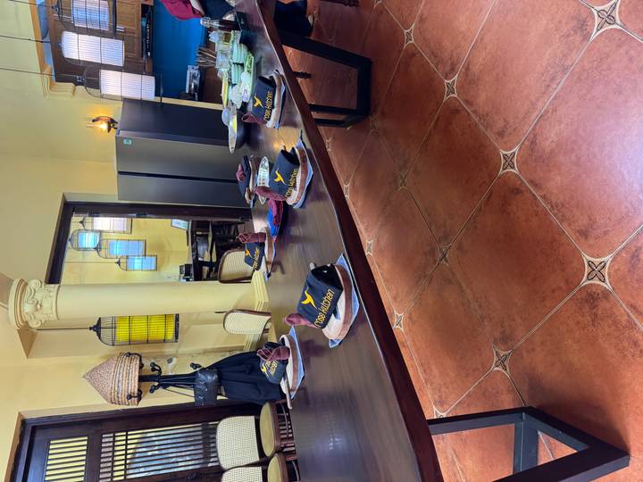 Long dining table set with aprons and utensils inside yellow-walled cooking studio