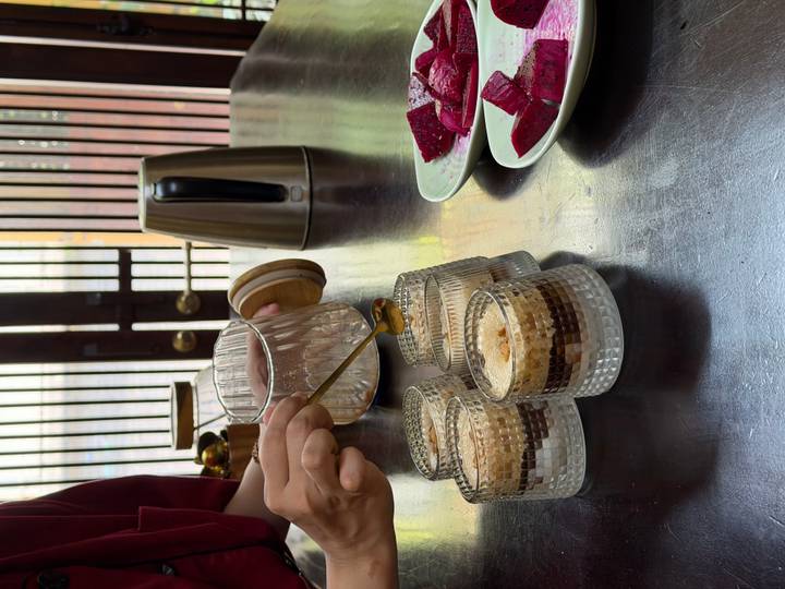 Chef drizzles syrup over layered Vietnamese egg coffee desserts beside sliced beetroot.
