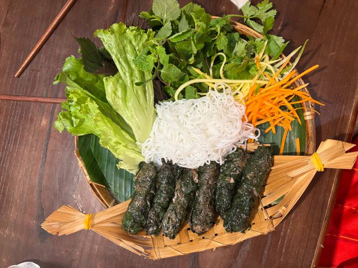 Vietnamese dish of minced meat wrapped in betel leaves served with rice noodles, fresh herbs and vegetables.