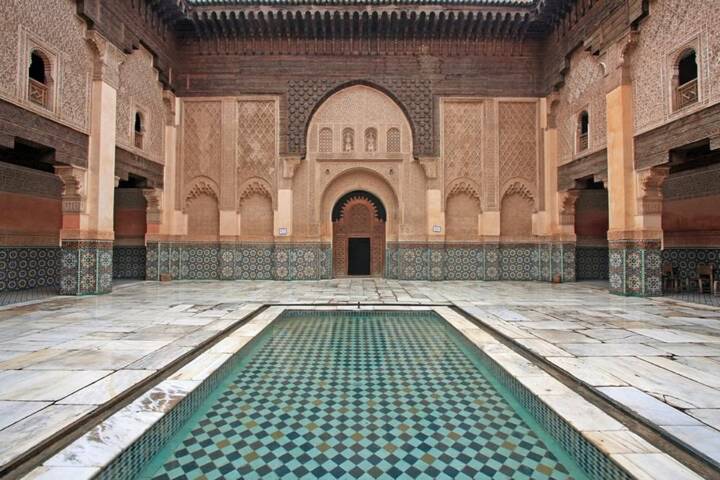 Tile-lined courtyard and reflecting pool inside Ben Youssef Madrasa captured from head-on perspective.