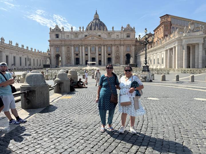 Tourists posing in St. Peter's Square with the basilica facade behind
