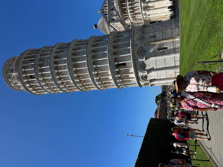 Leaning Tower of Pisa against a cloudless sky with tourists in foreground